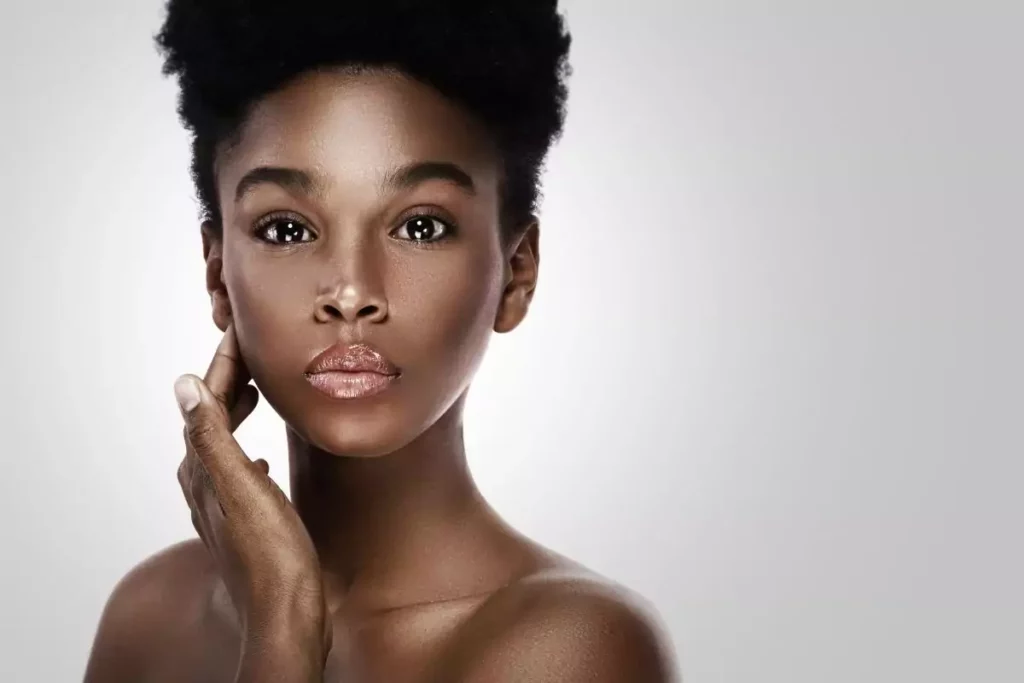 “Glow” en beauté : signification exacte et pourquoi ce mot change notre façon de soigner la peau 1 femme à la peau noire marron avec joli teint glow, sérum anti-tâches