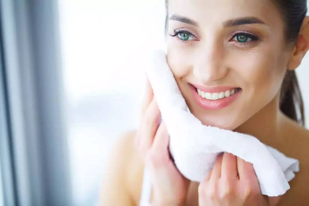 Femme qui s'essuie le visage apres la douche pour illustrer l'article peau seche ou peau déshydratée