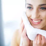 Femme qui s'essuie le visage apres la douche pour illustrer l'article peau seche ou peau déshydratée